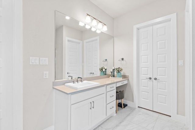 bathroom featuring marble finish floor, baseboards, a closet, and vanity