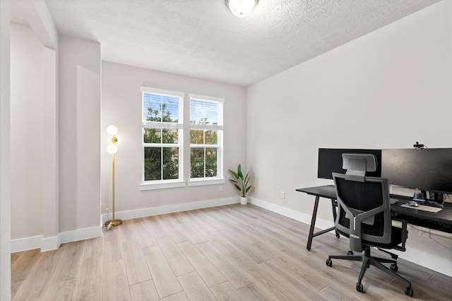 office area featuring a textured ceiling, baseboards, and wood finished floors