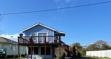 back of property with a sunroom and a deck