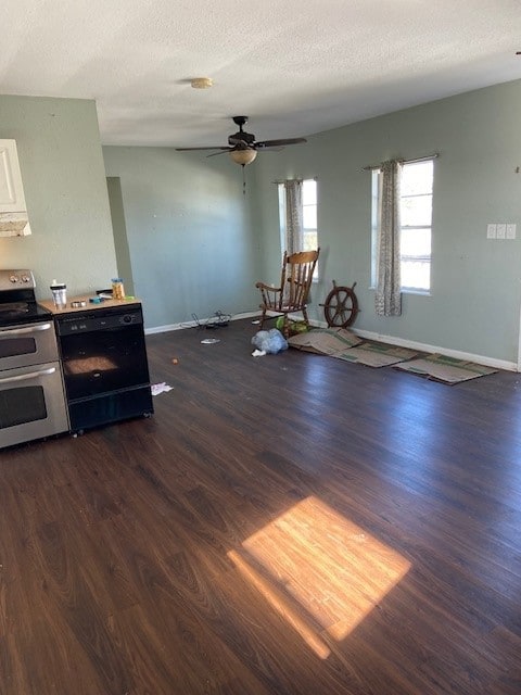 interior space featuring a textured ceiling, dark wood-type flooring, range with two ovens, dishwasher, and white cabinetry