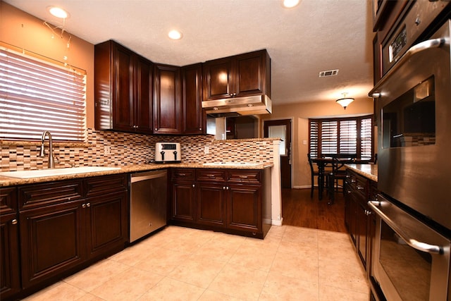 kitchen featuring light tile patterned flooring, backsplash, stainless steel appliances, and sink