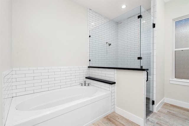 bathroom featuring shower with separate bathtub and hardwood / wood-style flooring