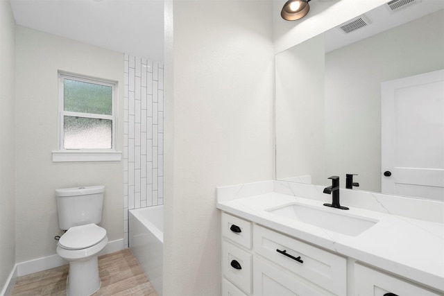 full bathroom featuring hardwood / wood-style floors, vanity, toilet, and tub / shower combination