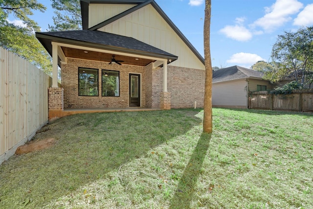 back of house featuring a yard and ceiling fan