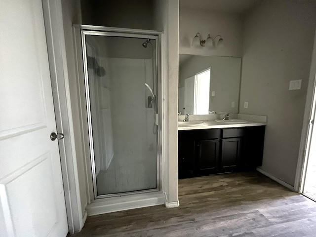 bathroom featuring a shower with door, vanity, and hardwood / wood-style flooring