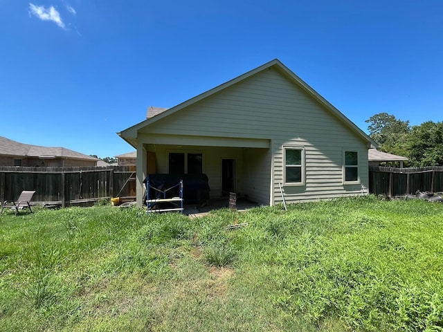 rear view of house featuring a yard