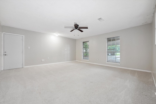 unfurnished room with light carpet, baseboards, visible vents, and a ceiling fan