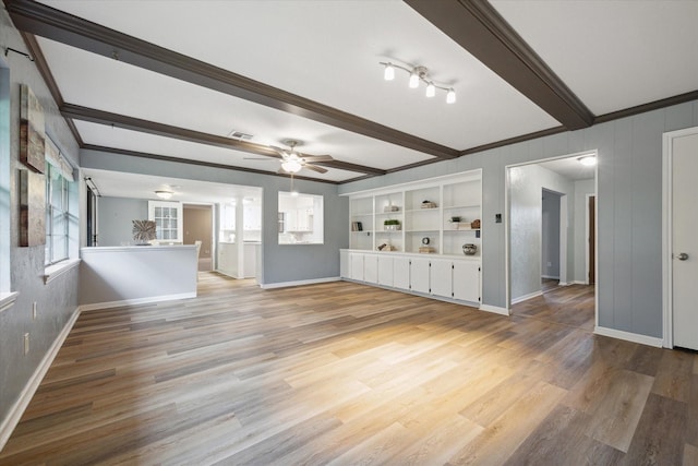 unfurnished living room featuring light wood-type flooring, beam ceiling, crown molding, and ceiling fan