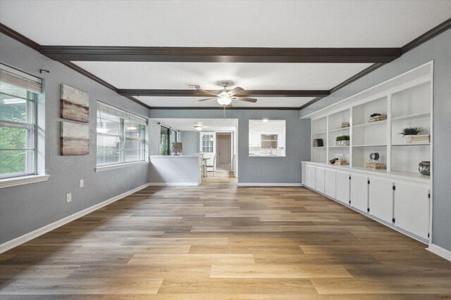 spare room featuring light wood finished floors, ceiling fan, baseboards, and beam ceiling