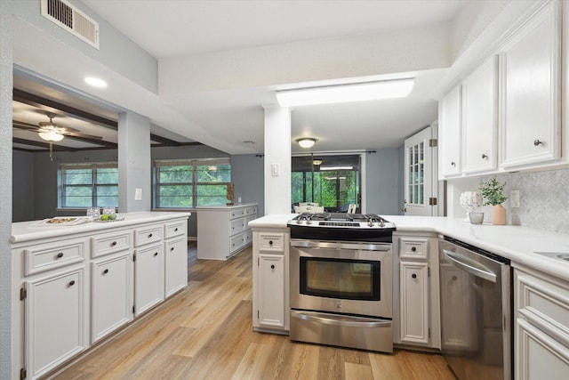 kitchen featuring stainless steel appliances, light countertops, visible vents, and white cabinets