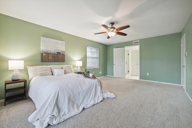 carpeted bedroom featuring a ceiling fan, visible vents, and baseboards