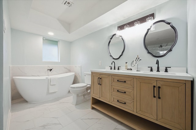 bathroom with a freestanding bath, marble finish floor, a sink, and visible vents