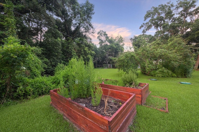 view of home's community featuring a lawn and a garden