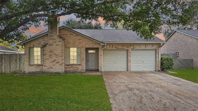 single story home with a garage and a lawn