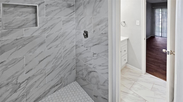 bathroom with vanity and a tile shower