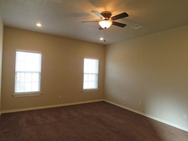 carpeted empty room with ceiling fan and a healthy amount of sunlight