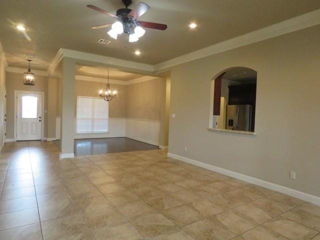 empty room with ceiling fan with notable chandelier, light tile patterned floors, and crown molding