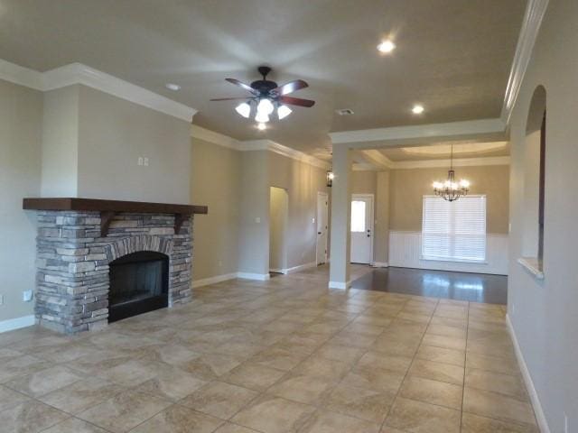 unfurnished living room with a fireplace, ceiling fan with notable chandelier, and crown molding