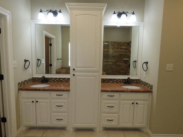 bathroom featuring tile patterned flooring, vanity, and tasteful backsplash