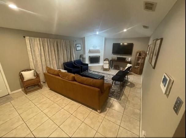 living room with light tile patterned flooring and a fireplace