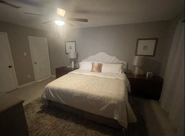 bedroom featuring dark colored carpet and ceiling fan