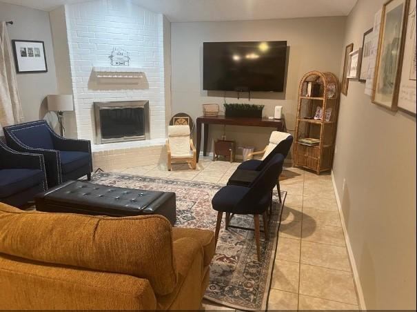 tiled living room with a brick fireplace