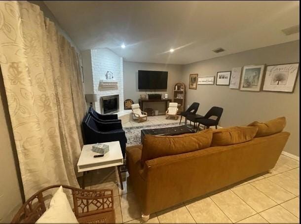 tiled living room with a fireplace and vaulted ceiling