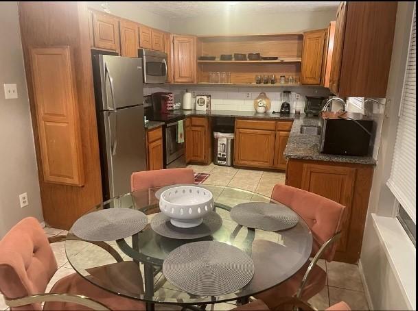 kitchen featuring sink, light tile patterned floors, and stainless steel appliances