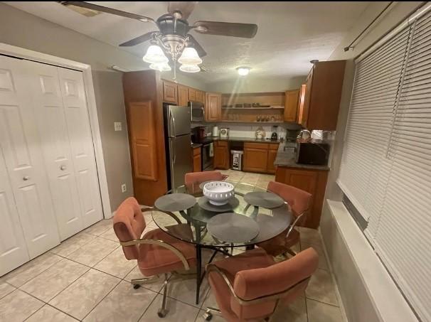 tiled dining space featuring ceiling fan