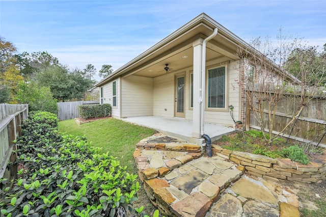 rear view of house featuring ceiling fan, a yard, and a patio