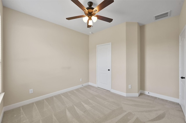 carpeted spare room featuring ceiling fan