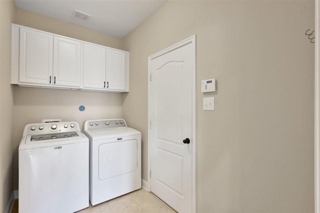 washroom with cabinets, washer and clothes dryer, and light tile patterned flooring