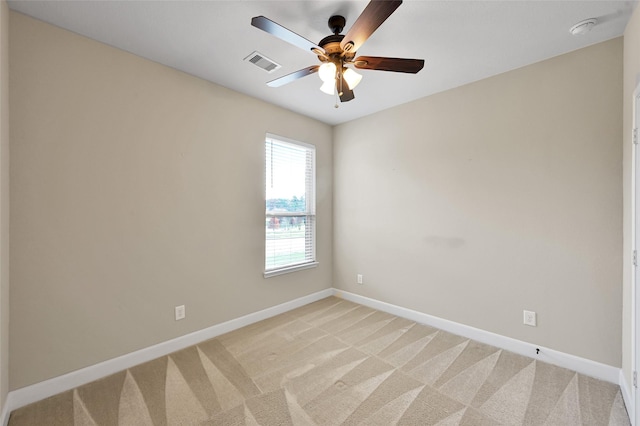 spare room featuring light carpet and ceiling fan