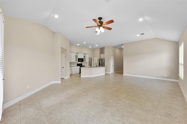 unfurnished living room with ceiling fan, lofted ceiling, and sink