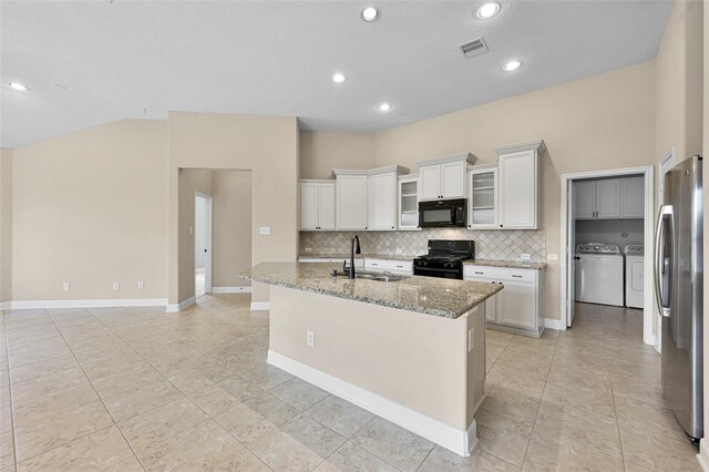 kitchen with white cabinetry, sink, an island with sink, black appliances, and washer and dryer