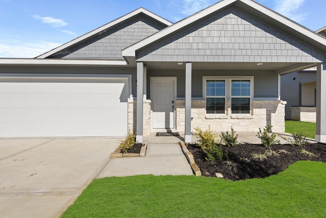 craftsman inspired home with a front yard, a garage, and covered porch