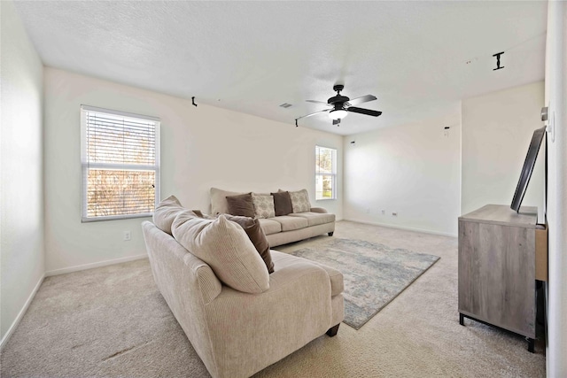 living room with ceiling fan, light colored carpet, and a wealth of natural light