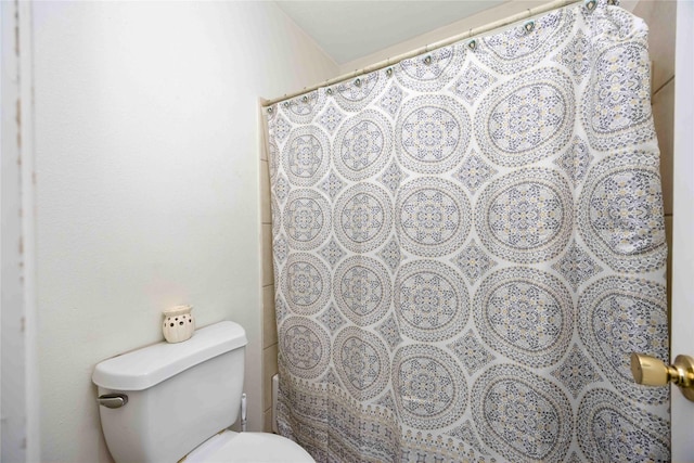 bathroom with a shower with curtain and toilet