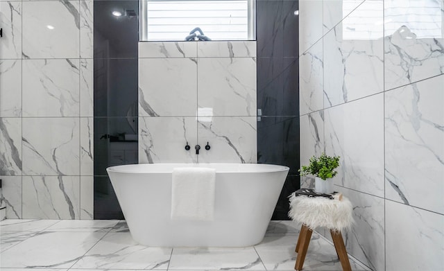 bathroom with a bath and tile walls