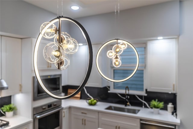 interior details featuring white cabinets, stainless steel appliances, and sink