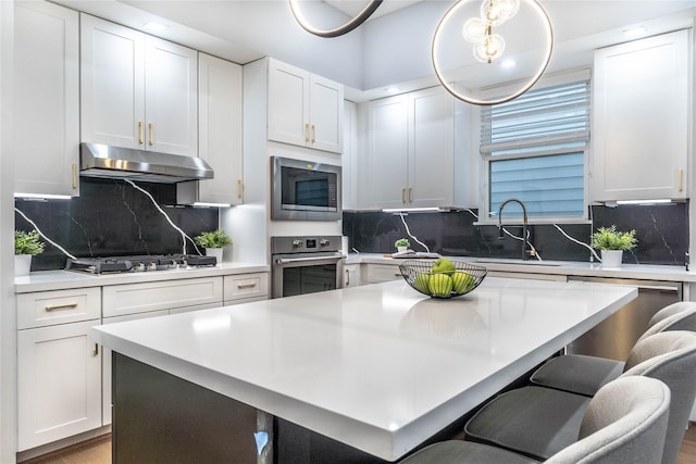 kitchen featuring decorative backsplash, appliances with stainless steel finishes, and white cabinetry