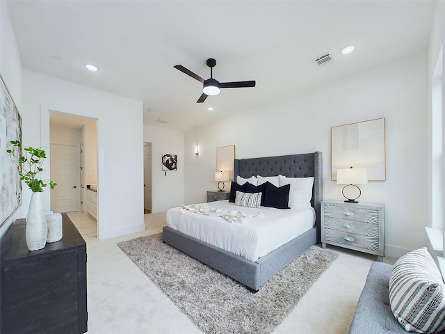 bedroom with light carpet, ceiling fan, and ensuite bathroom