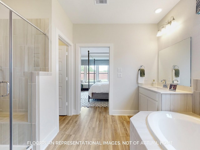 bathroom with plus walk in shower, vanity, and wood-type flooring