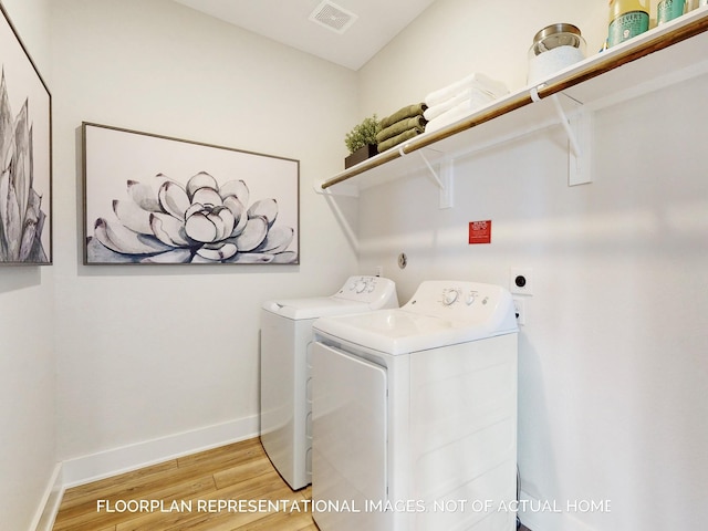 clothes washing area featuring washing machine and dryer and hardwood / wood-style floors