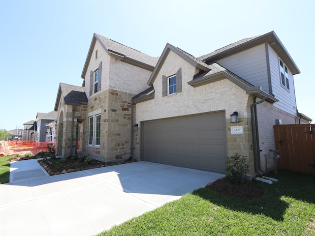 8327 Oceanmist Cove Dr, Cypress, TX 77433 - view of front of property featuring stone siding, a shingled roof, driveway, and fence