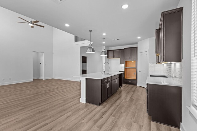 8327 Oceanmist Cove Dr, Cypress, TX 77433 - kitchen with a sink, open floor plan, ceiling fan, tasteful backsplash, and dark brown cabinetry
