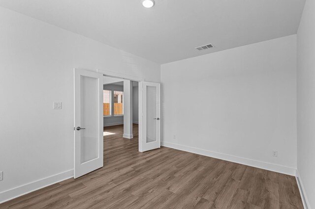 8327 Oceanmist Cove Dr, Cypress, TX 77433 - empty room featuring wood finished floors, baseboards, and french doors