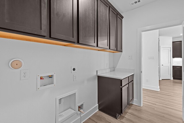 8327 Oceanmist Cove Dr, Cypress, TX 77433 - laundry room with cabinet space, hookup for a washing machine, electric dryer hookup, light wood finished floors, and baseboards