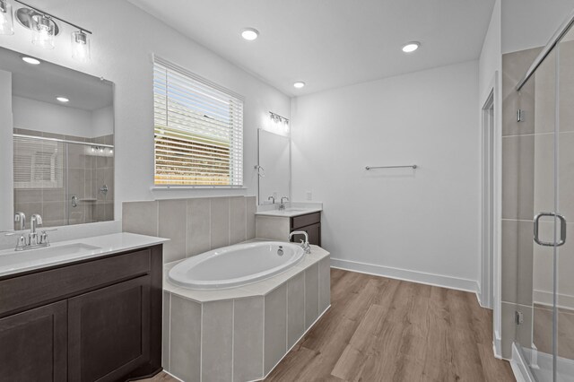 8327 Oceanmist Cove Dr, Cypress, TX 77433 - full bath with a shower stall, wood finished floors, two vanities, a garden tub, and recessed lighting