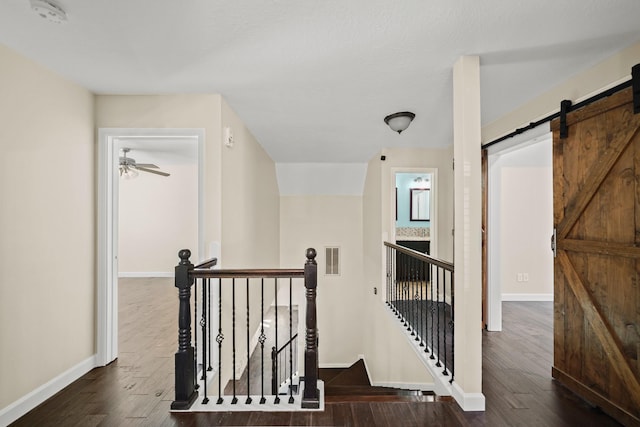 hallway with dark hardwood / wood-style flooring and a barn door